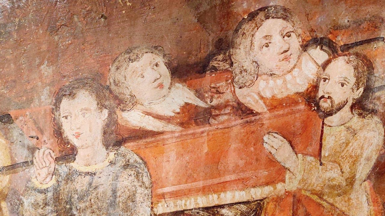Men carrying a casket of angels depicted in a mural at the chapel of Holy Trinity