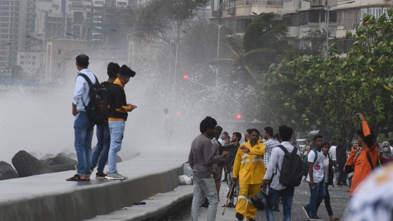 Police alerting people to move away from Marine Drive promenade during high tide in heavy rain Pic/Ashish Raje
