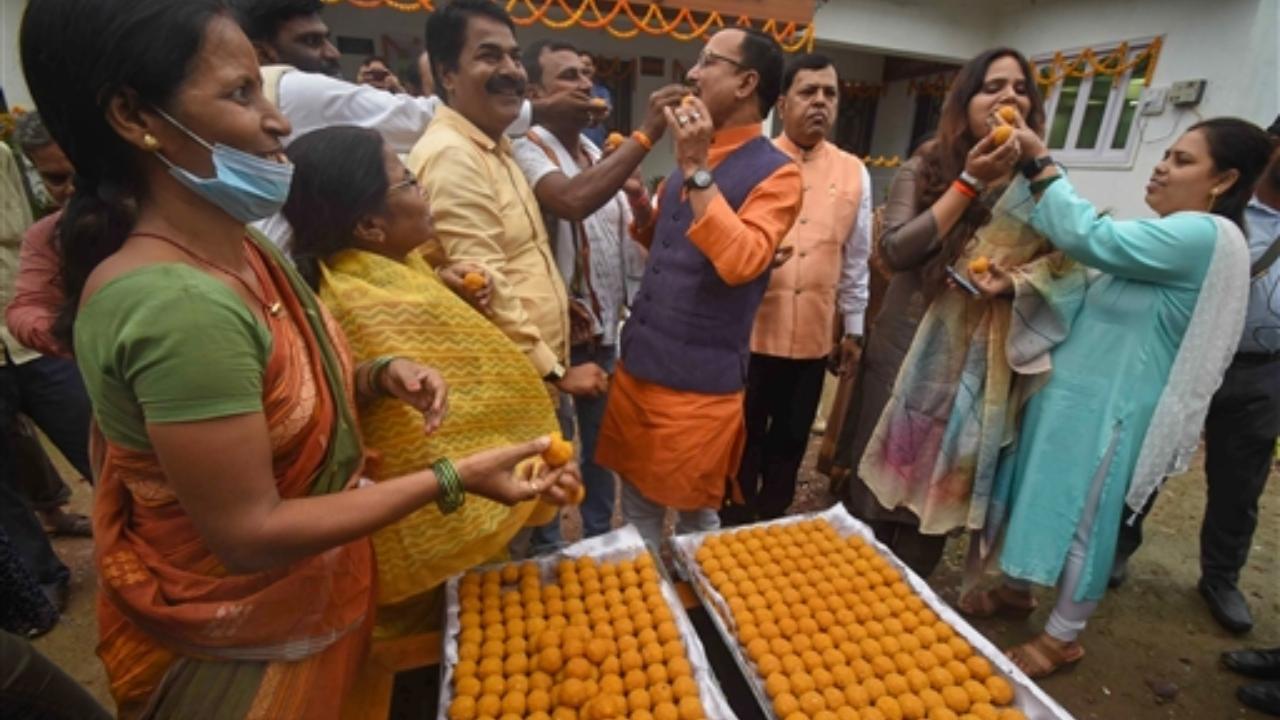 Rashtriya Lok Janshakti Party workers feed each other sweets in Patna as they celebrate NDA's presidential candidate Droupadi Murmu's lead during counting of votes to elect the 15th President