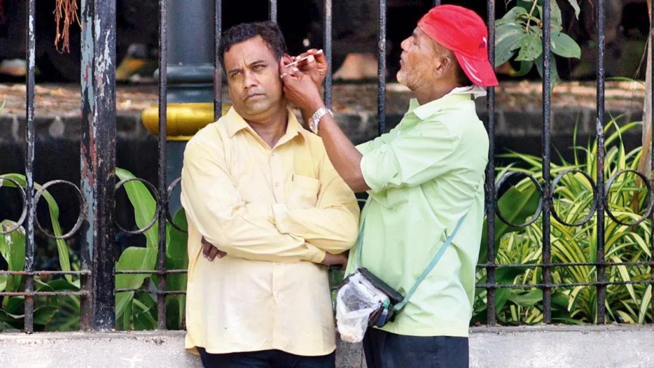 Lending his ear: A man gets his ear cleaned by a professional near Chhatrapati Shivaji Maharaj Terminus. Pic/Pradeep Dhivar
