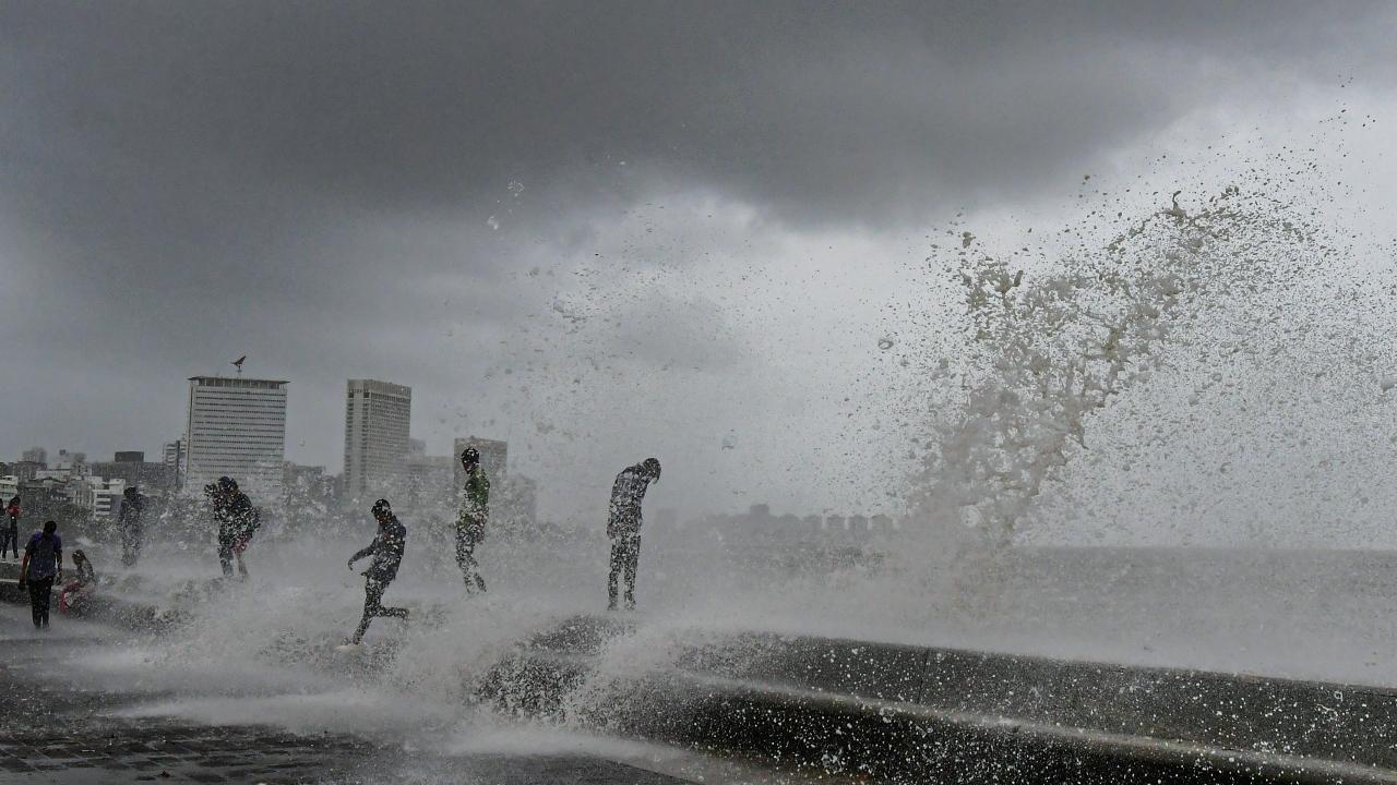  People visit the Marine Drive as sea waves crash on the shore during a high tide in Mumbai. Pic/PTI