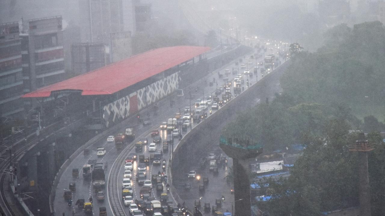 Vehicles ply on a road amid monsoon rains in Mumbai on Wednesday. Pic/PTI