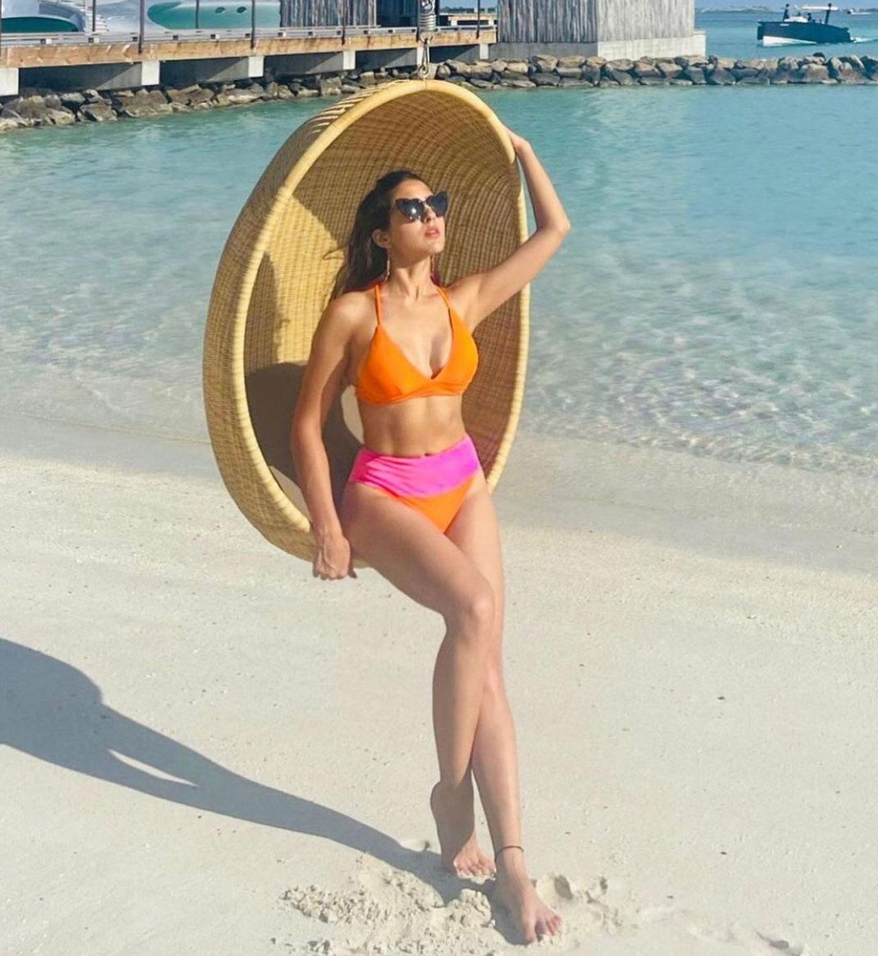 In this look, we see Sara Ali Khan dazzling in an orange and pink bikini and the actress styled her look with sunglasses, looking very charismatic. The caption here read- 