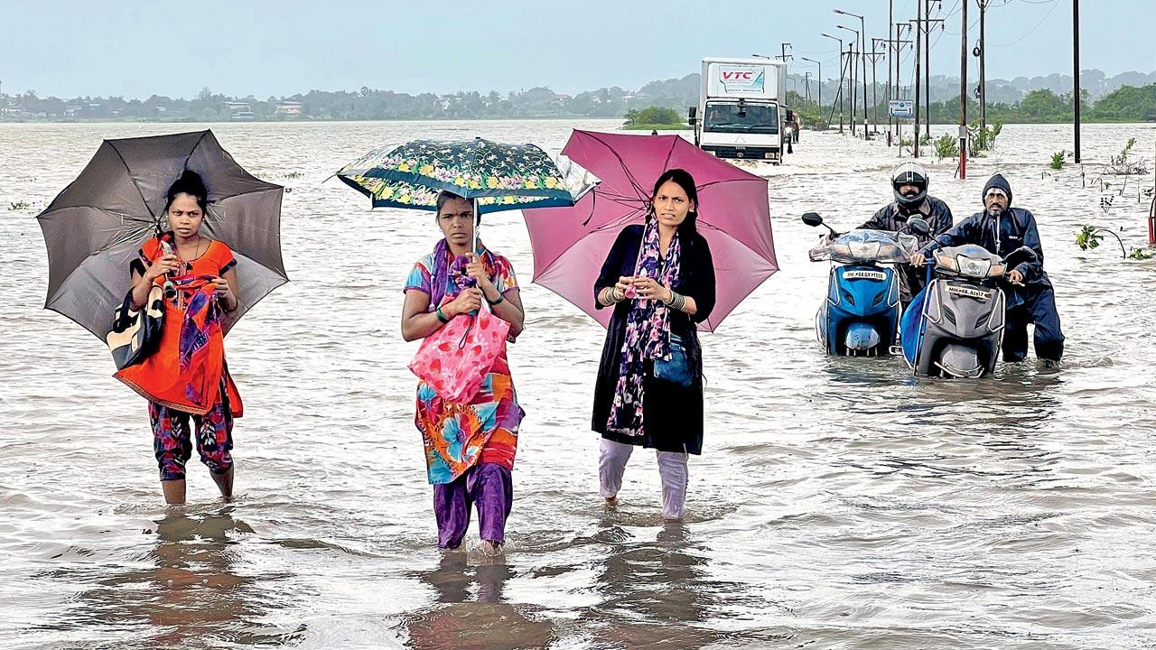 Locals wade through knee-deep water at Vasai Suncity