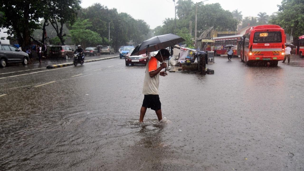 A man walking amid heavy rains in Mumbai