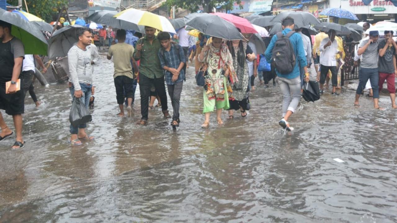 In Kurla west people were seen walking in the waterlogged street on Wednesday morning. Pic/Sayed Sameer Abedi