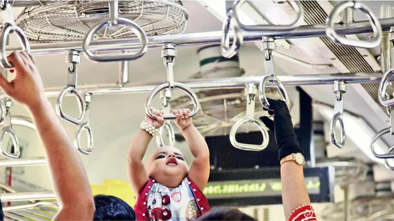 Handle, with care: A toddler held up by its parent takes baby steps on getting used to Mumbai’s locals, on a Kalyan-bound train. Pic/Atul Kamble