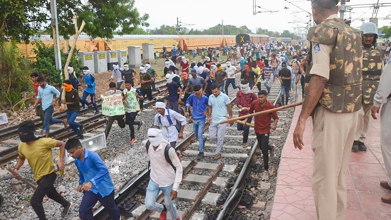 Youngsters were chased away by police personnel during a protest , at Birlanagar Junction railway station, in Gwalior, against government's newly introduced 'Agnipath' scheme on June 16. Pic/ PTI
