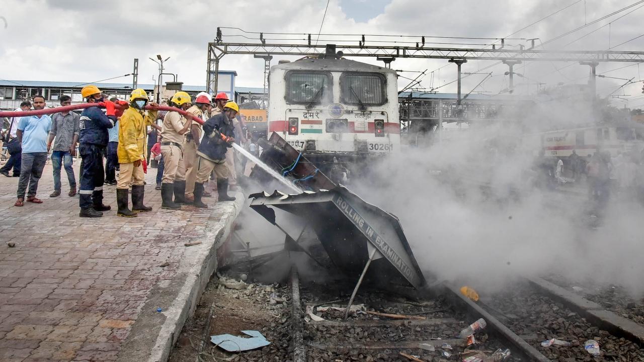 Fire Brigade personnel douse fire on a train set ablaze by a mob at the Secunderabad Railway Station near Hyderabad in protest against ‘Agnipath’ scheme on Friday. Pic/ PTI