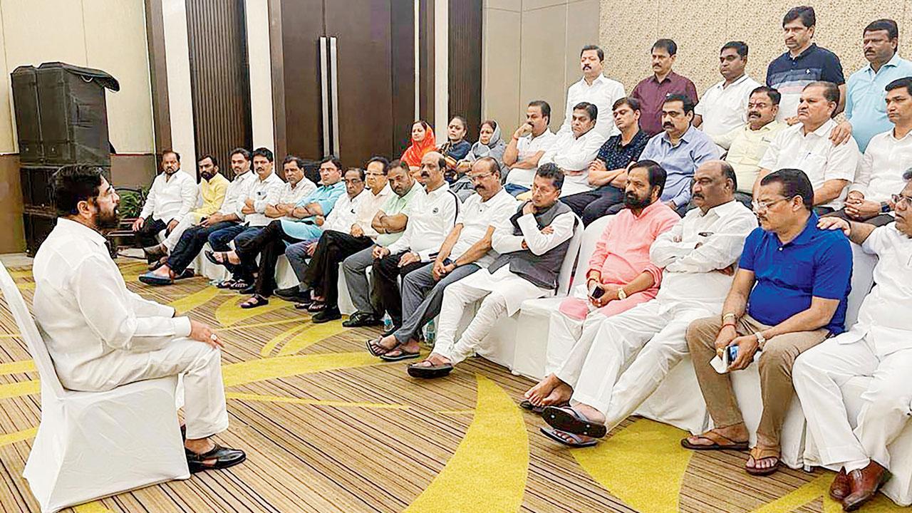 Rebel Shiv Sena leader Eknath Shinde interacts with supporting MLAs at a hotel in Guwahati on Thursday. Pic/PTI