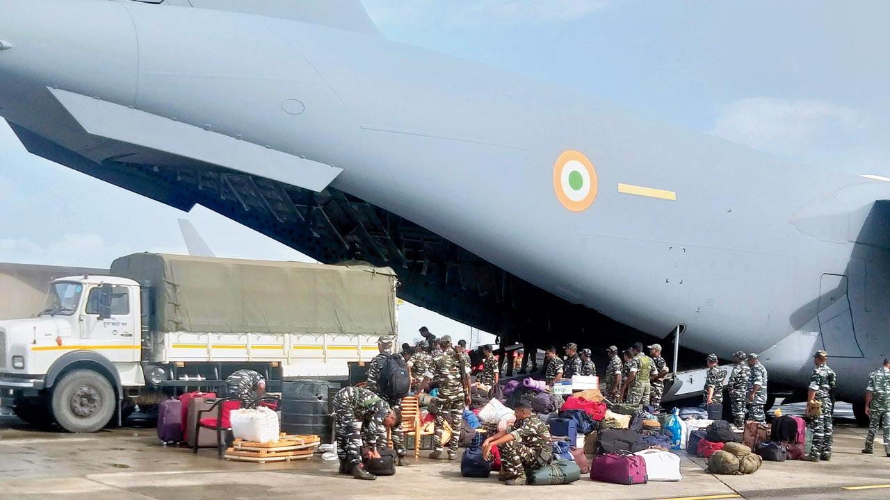 Security personnel get down from an IAF jumbo plane at city airport