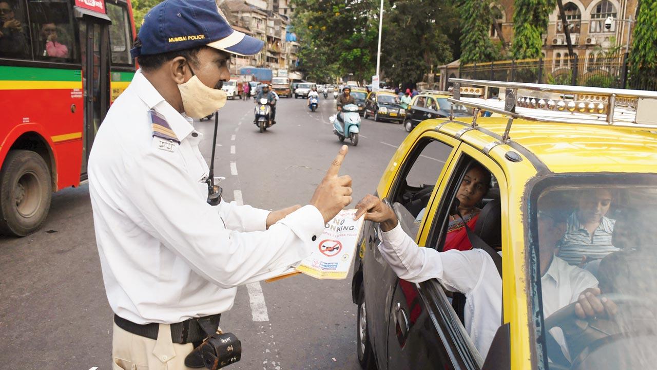 Crawford Market: A traffic constable hands out pamphlets to a motorist at Crawford Market. Pic/Ashish Raje