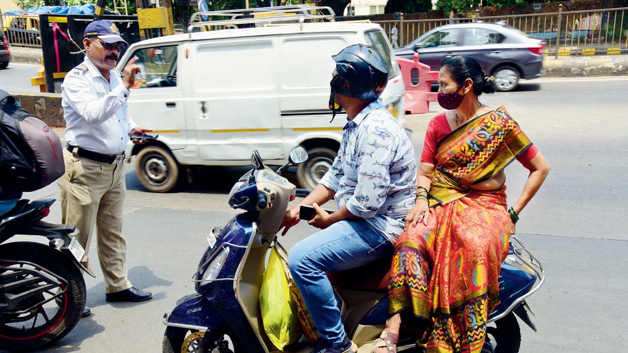A cop stops a bike as the pillion rider is without a helmet, at Lalbaug on Thursday. Pic/Pradeep Dhivar