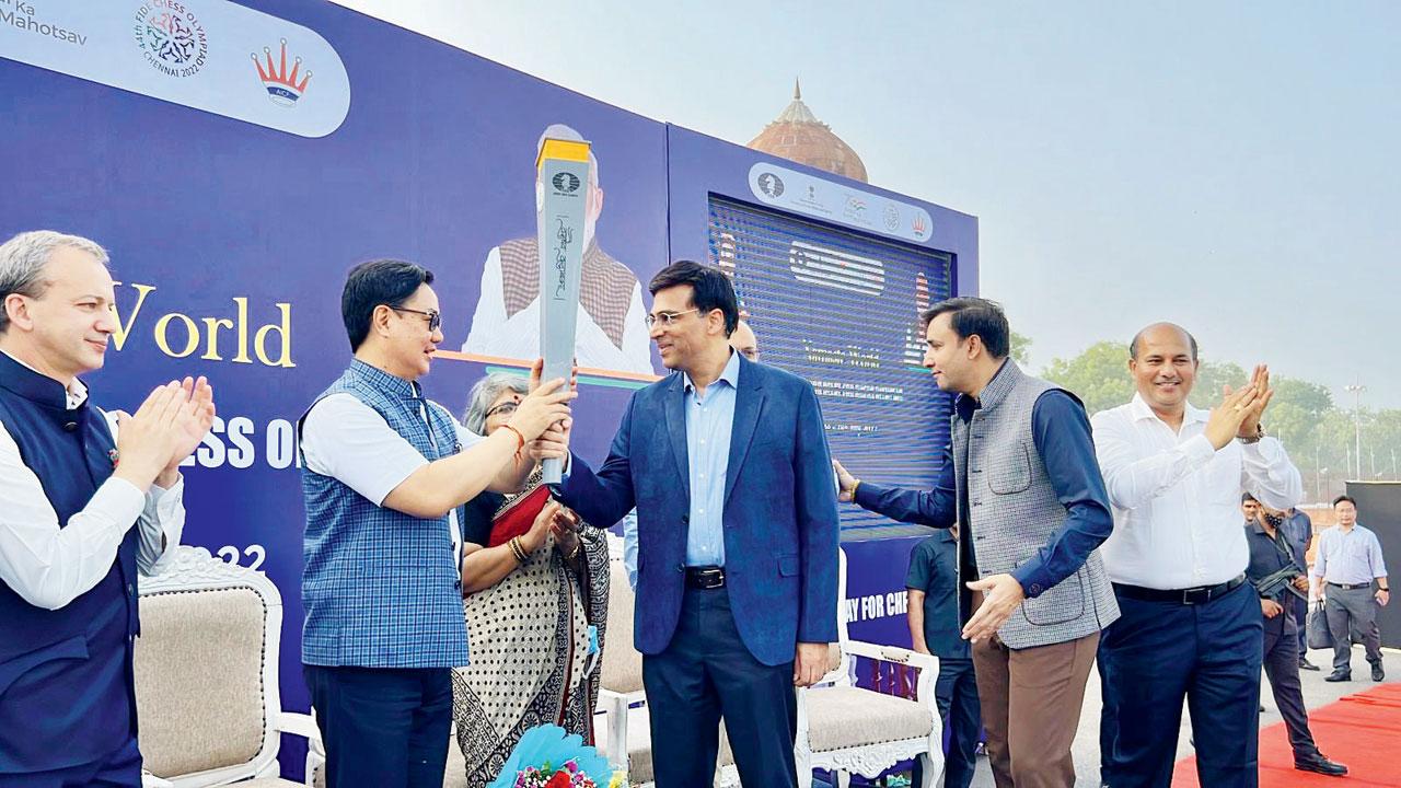 Union apportion Kiren Rijiju receives a Chess Olympiad flame from Viswanathan Anand. Pic courtesy/ Twitter