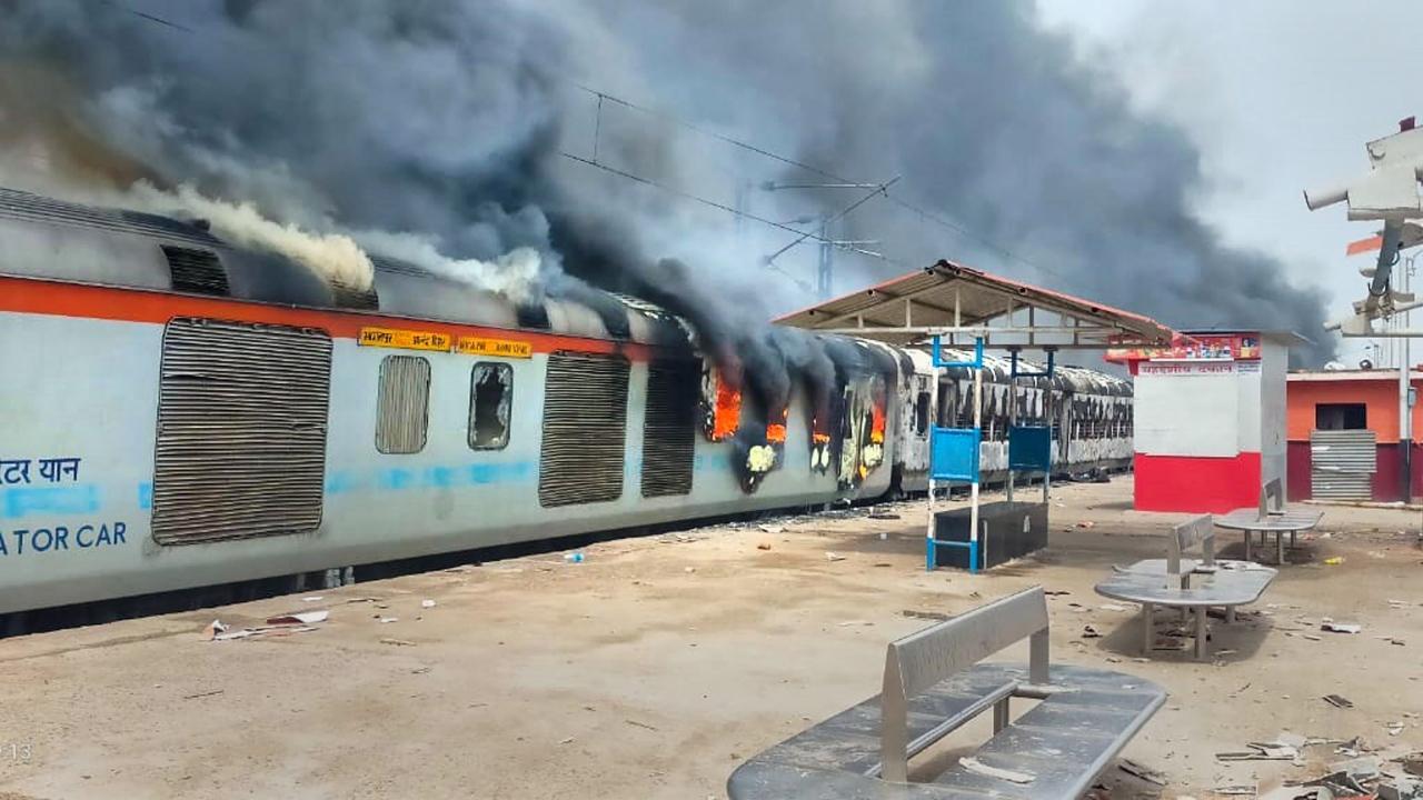 A train set on fire by youngsters in protest against the Centre's 'Agnipath' scheme at Lakhisarai Railway Station, in Lakhisarai on Friday. Pic/ PTI