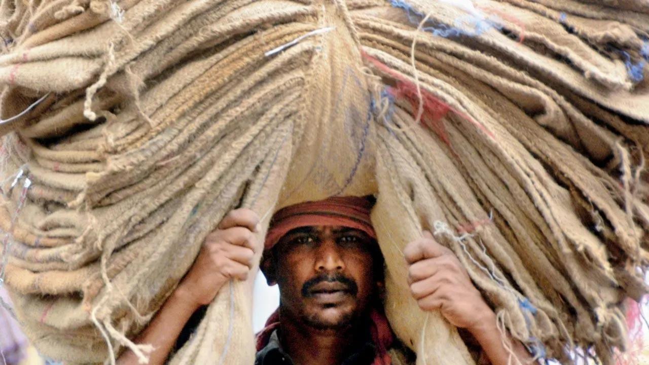 Sack of all trades: A worker carries a huge pile of gunny bags on his head on a street in Masjid Bunder. Pic/Satej Shinde
