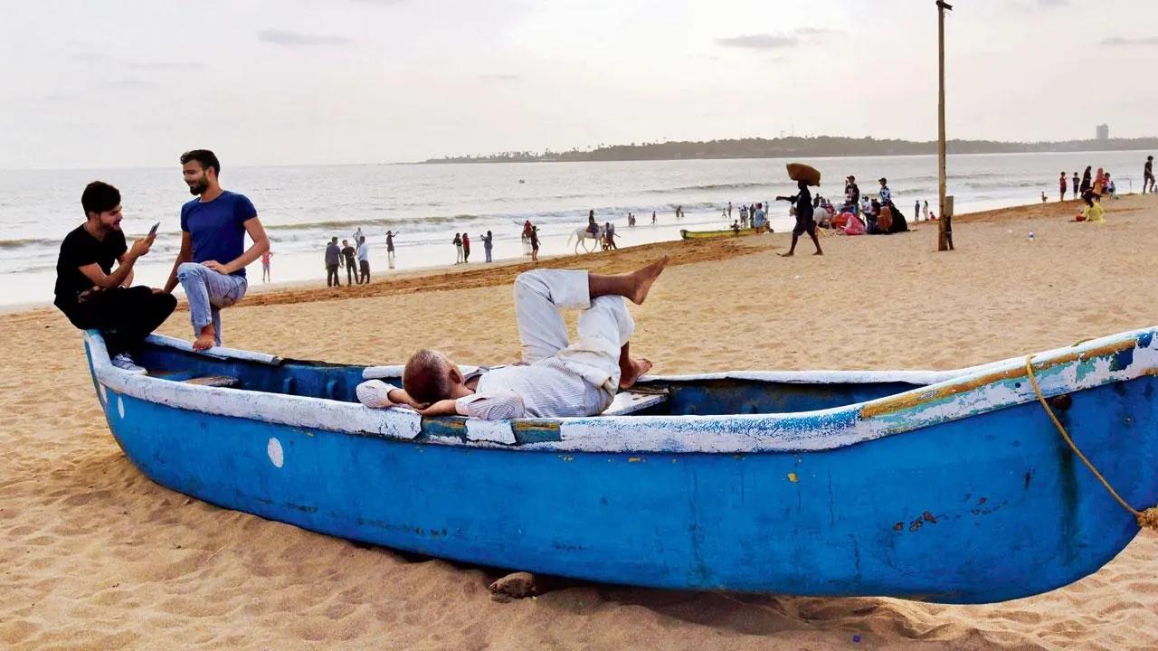 Old man and the sea: After the day’s toil, a dabbawala relaxes on an anchored boat on Versova beach. Pic/Nimesh Dave