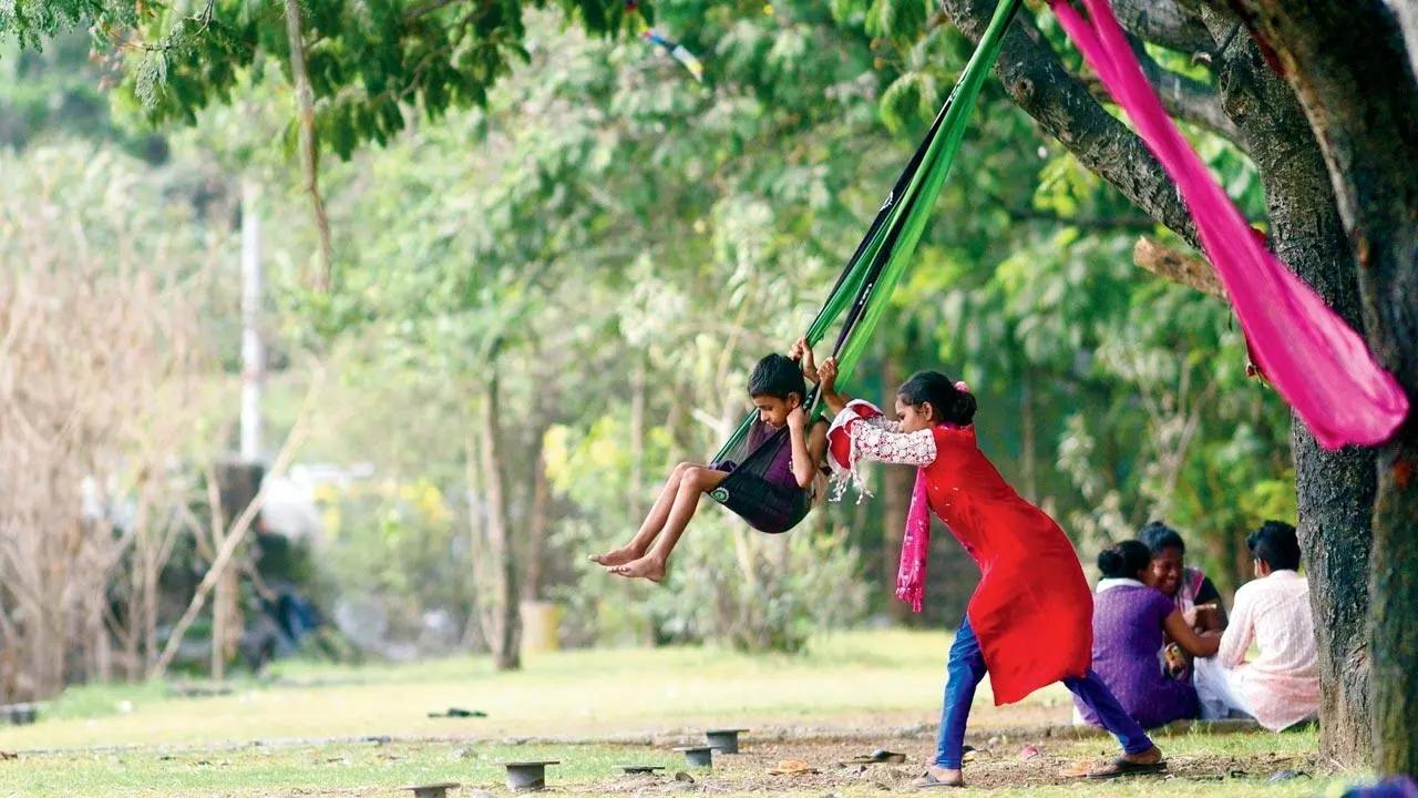 That's how you swing: A girl gives her playmate a push on their dupatta-turned-swingset in Wadala. Pic/Pradeep Dhivar
