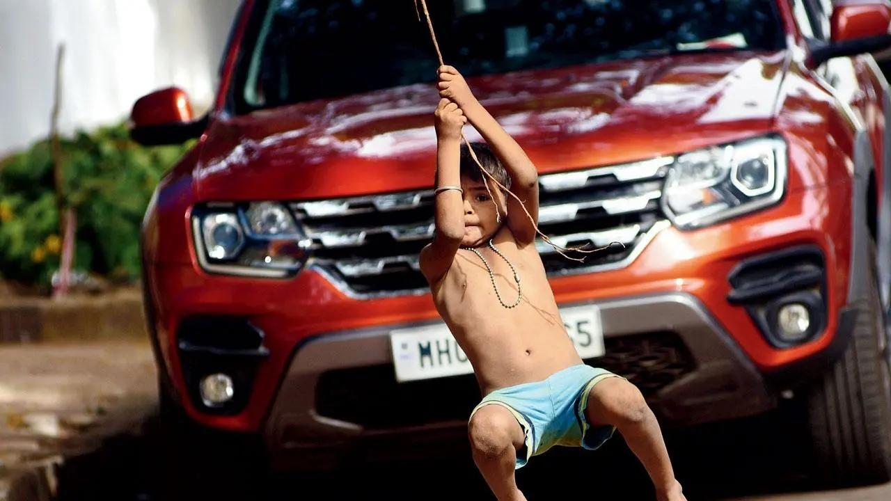 Yabba-Dabba-Doo: A child swings with abandon from the root of a banyan tree at Shivaji Park in Dadar. Pic/Pradeep Dhivar