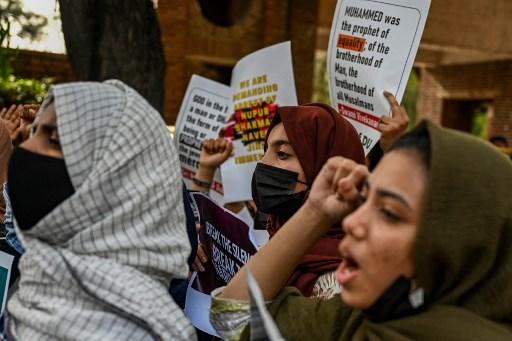 Students from Delhi university display placards and shout slogans during a demonstration to condemn police firing