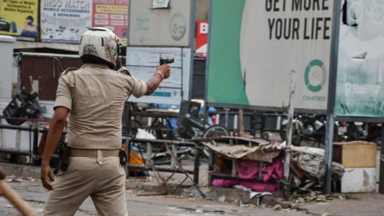A policeman aims a handgun at demonstrators during a protest against former India's Bharatiya Janata Party spokeswoman Nupur Sharma. Pic/Nupur Sharma