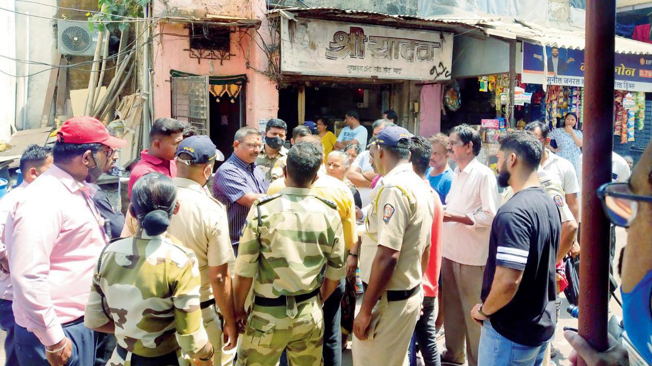 Police and the Maharashtra Security Force accompany Adani Electricity Mumbai Limited officials for power disconnection, at Siddharth Colony, Chembur, on Tuesday