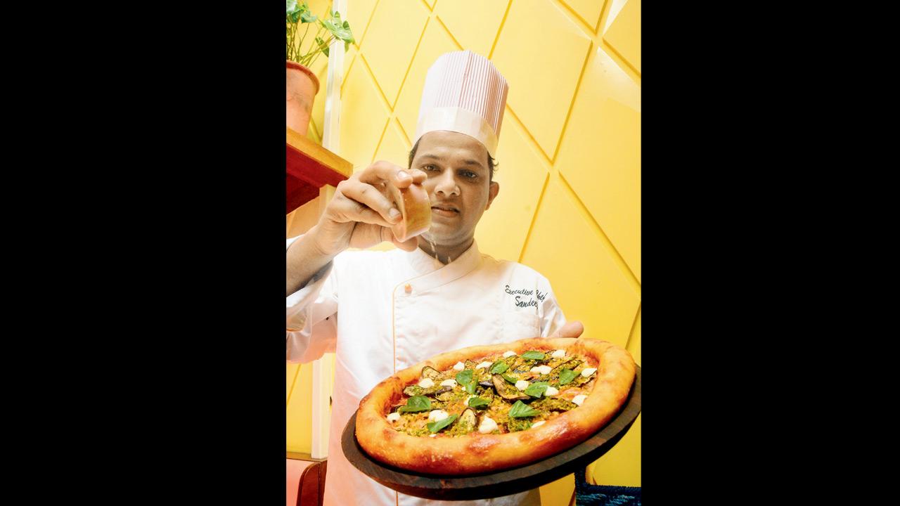 Chef Sandip Dalvi drizzles thecha oil over spicy nona pizza at Bandra’s Jamjar Diner. Pcis/Sameer Markande