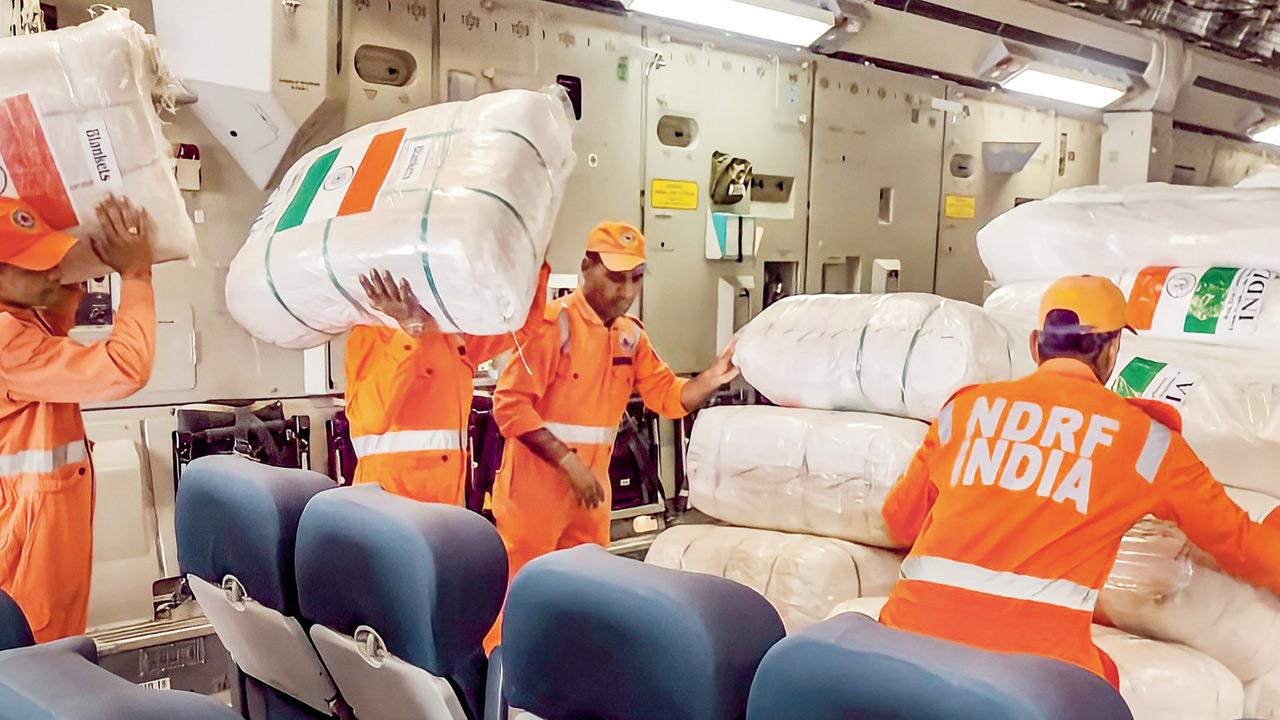 NDRF personnel load relief material on an Indian Air Force aircraft at Hindon airbase, to be flown to Romania for the evacuated Indian students, in Ghaziabad. Pic/PTI
