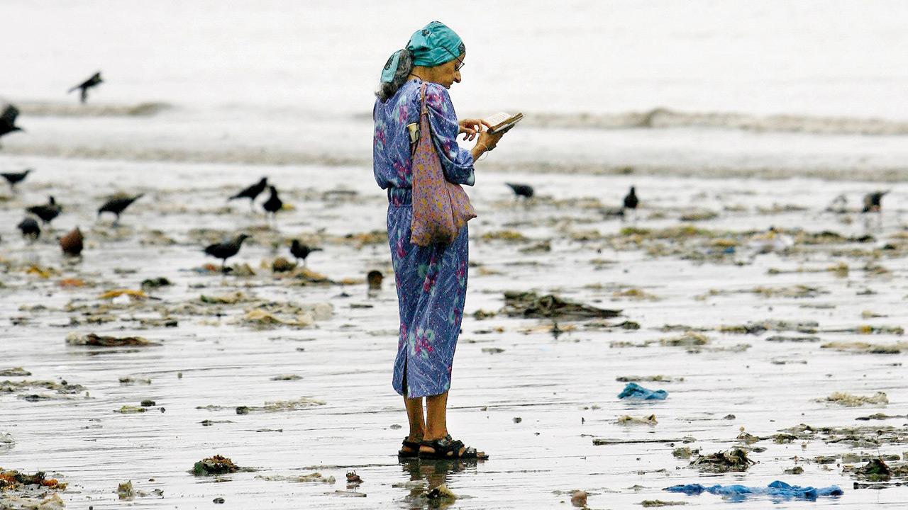 A file photo of a Parsi woman offering prayers to the water at Girgaum Chowpatty. Zoroastrians flock to water bodies on Avan mahino (month) Avan roj (day) every year to pay their respect. Pic/Getty Images