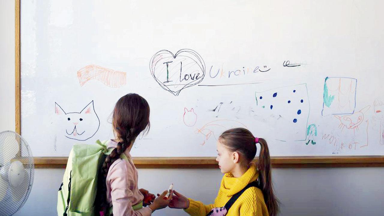 Two girls from Ukraine in Berlin on Monday where classes are being held for refugees by two volunteers who raised funds for them. Pics/AP
