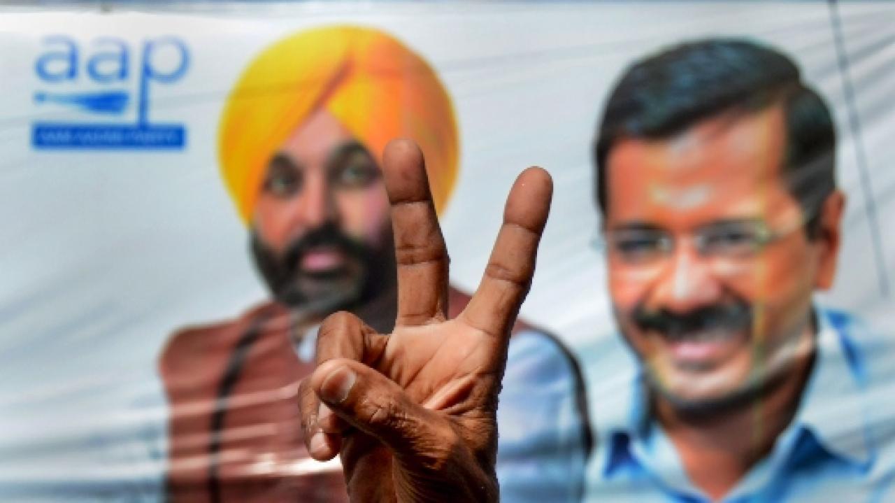 An Aam Aadmi Party (AAP) supporter flashes the victory sign, to celebrate the party's lead. Pic/PTI