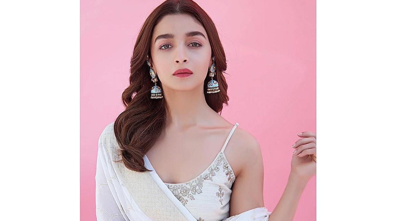 Alia's ivory sharara set with a strappy kurta, is perfectly ethnic chic! Red lips, jhumkas and hair left loose completed the look.