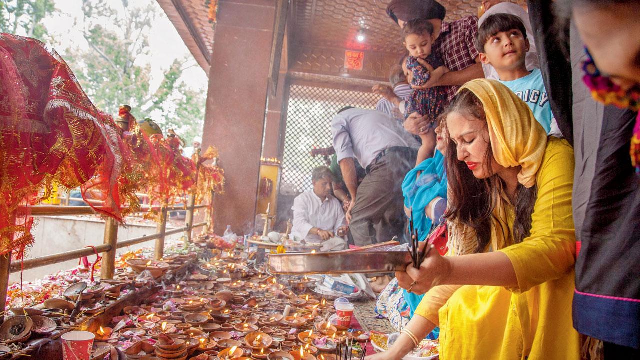 A Kashmiri Pandit devotee lights lamps during the annual Hindu festival of the Kheer Bhawani, in 2018 in Tullmull, 25 km east of Srinagar. Each year, thousands of Pandit devotees line up in spring with plates of sugar and milk to pay homage to the Goddess Kheer Bhawani. Pic/Getty Images