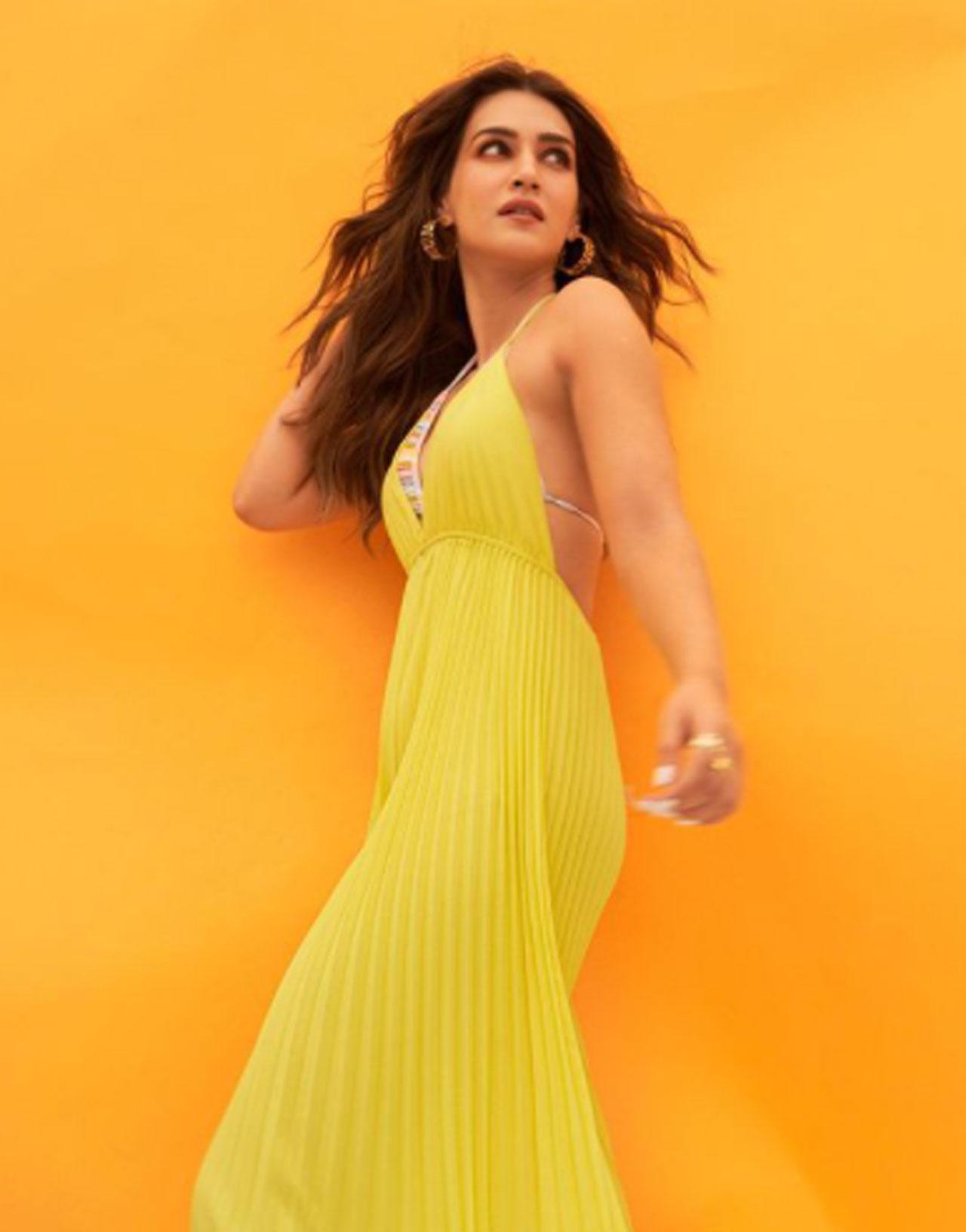 In one of the pictures, the actress sported a micro-pleated sunshine yellow jumpsuit featuring a plunging V halter neckline. She left her centre-parted hair open and accessorised up with golden earrings and rings.