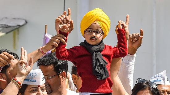 Young boy dressed up as Arvind Kejriwal and Bhagwant Mann with AAP supporters celebrate the party's win in Punjab Assembly polls, at the party headquarters. 