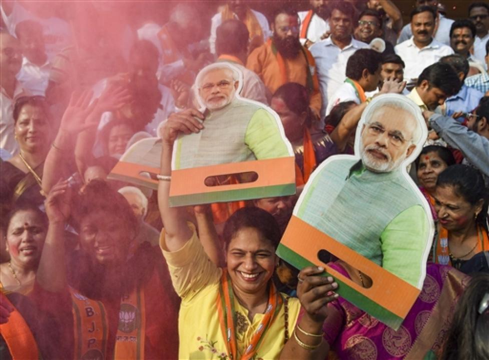  BJP supporters hold cutouts of Prime Minister Narendra Modi and celebrate the party`s performance in Assembly polls, at Shivaji Maharaj Chowk, in Navi Mumbai, on Thursday. Pic/ PTI