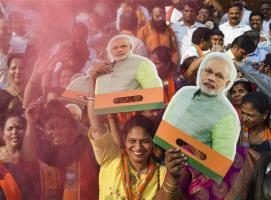  BJP supporters hold cutouts of Prime Minister Narendra Modi and celebrate the partys performance in Assembly polls at Shivaji Maharaj Chowk in Navi Mumbai on Thursday. Pic PTI