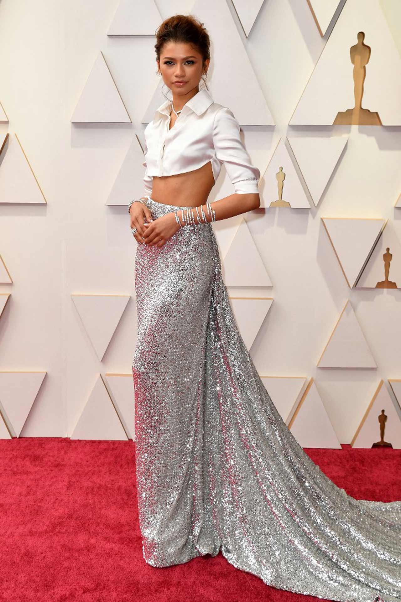 Zendaya, who continues to be the star of every red carpet she graces, arrived wearing a dazzling fully beaded silver skirt with a glossy button-up crop top, bold necklace and messy undone updo.