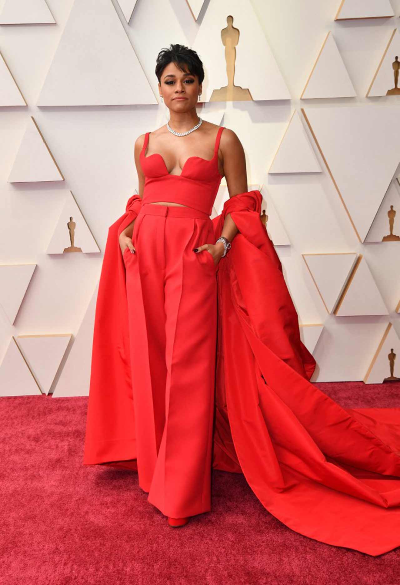 Ariana DeBose was nominated for 'West Side Story', rocked crimson pants look with a plunging bodice, wide-leg pants and voluminous cape.