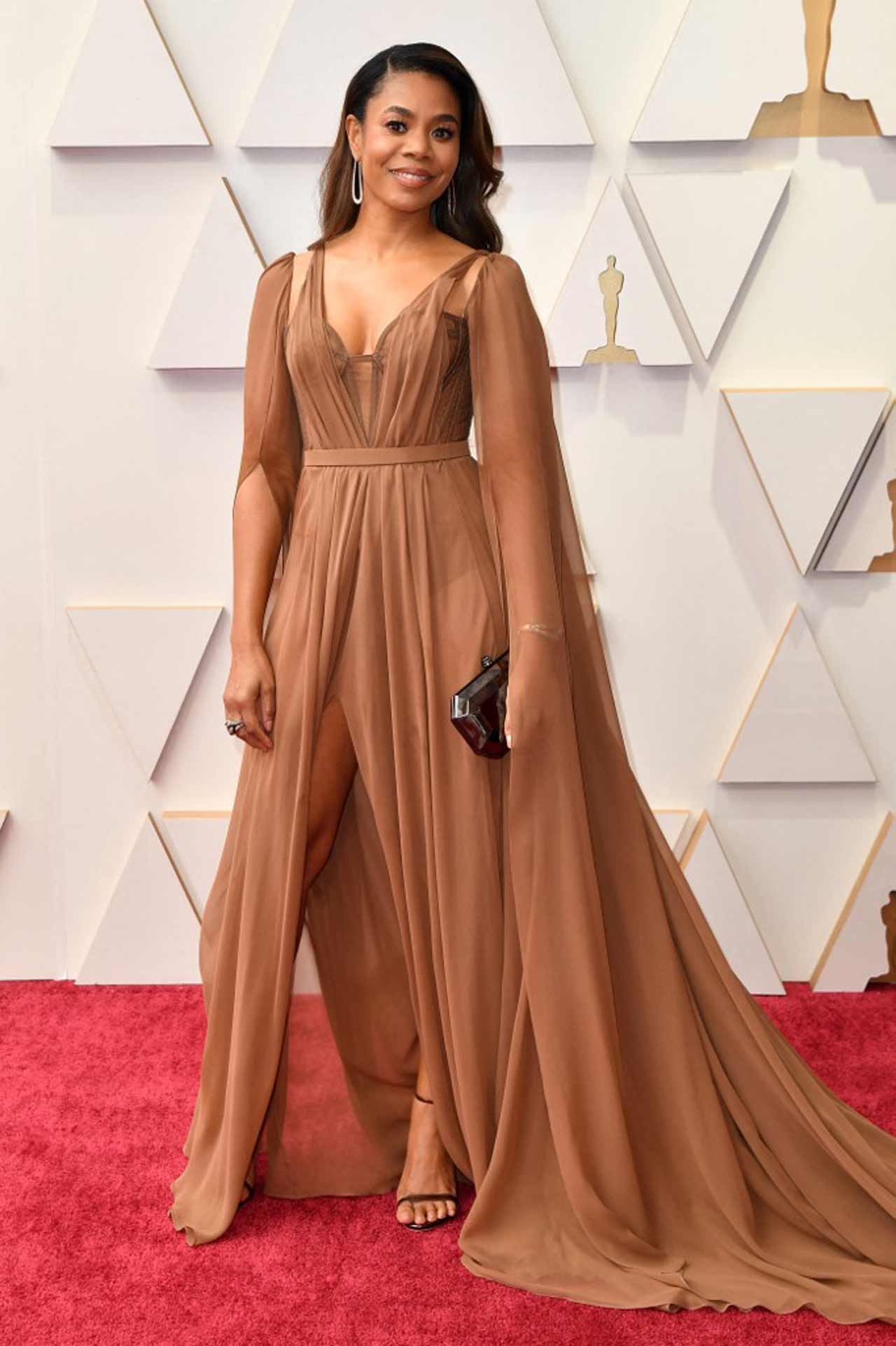 Oscar host Regina Hall sported a toffee-coloured gown with dramatic sheer sleeves.
