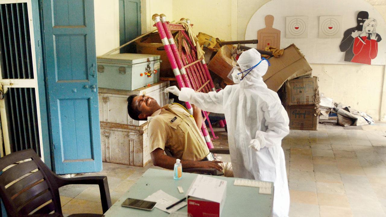 A health worker conducts a COVID-19 screening and swab test on a queasy policeman at Aarey police station, Goregaon, on October 26, 2020. Pic/Satej Shinde