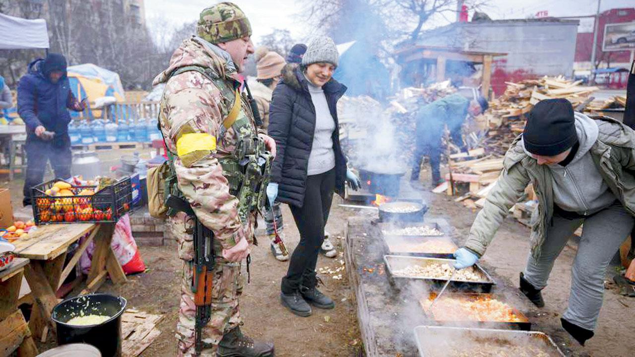 Kyiv: People cook for Ukrainian servicemen and civil defense members. Pics/AFP, AP