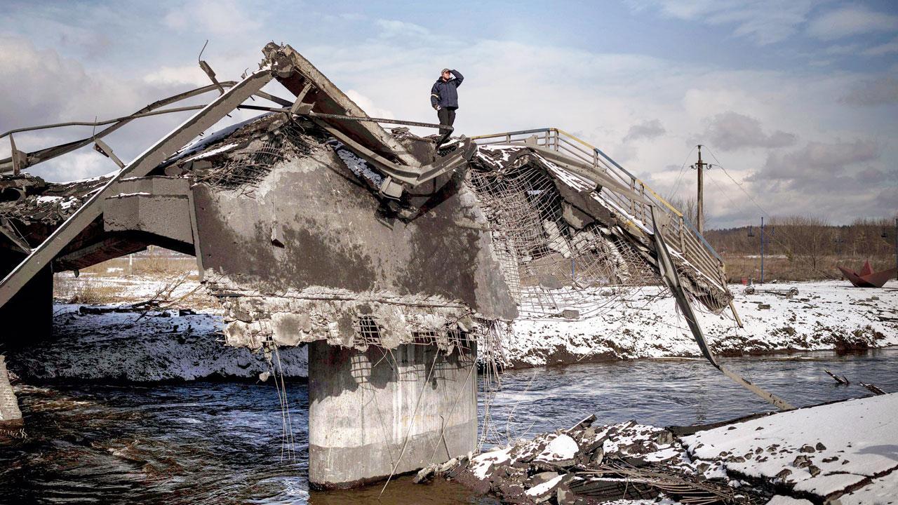 Kyiv: A man stands atop a destroyed bridge in Irpin, on the outskirts of Kyiv on Tuesday.
