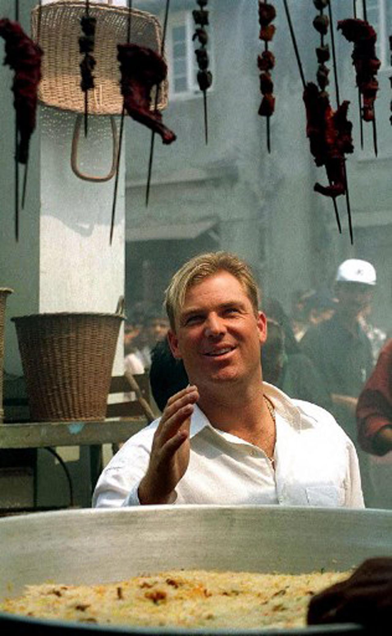 Shane Warne played 194 ODIs and took 293 wickets with best bowling figures of 5/33. In pic: Warne looks up at some kebabs and grilled chicken during a photoshoot in Mumbai in 2001.