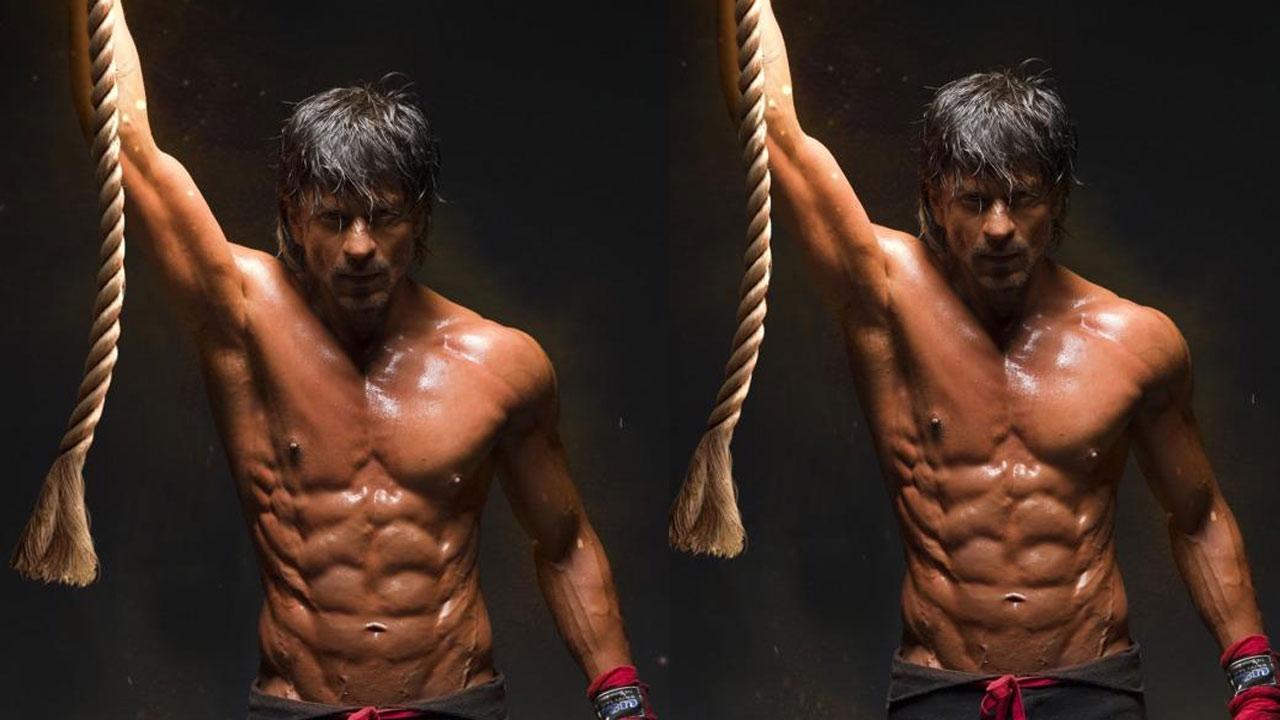 With his drastic physical transformation for the upcoming film 'Pathaan', superstar Shah Rukh Khan has undoubtedly made women weak in the knees. On Tuesday, new pictures of SRK emerged from the shoot of 'Pathaan' in Spain. The viral images feature shirtless King Khan showing off his ripped abs. He could be seen holding a beam above him. Read the full story here