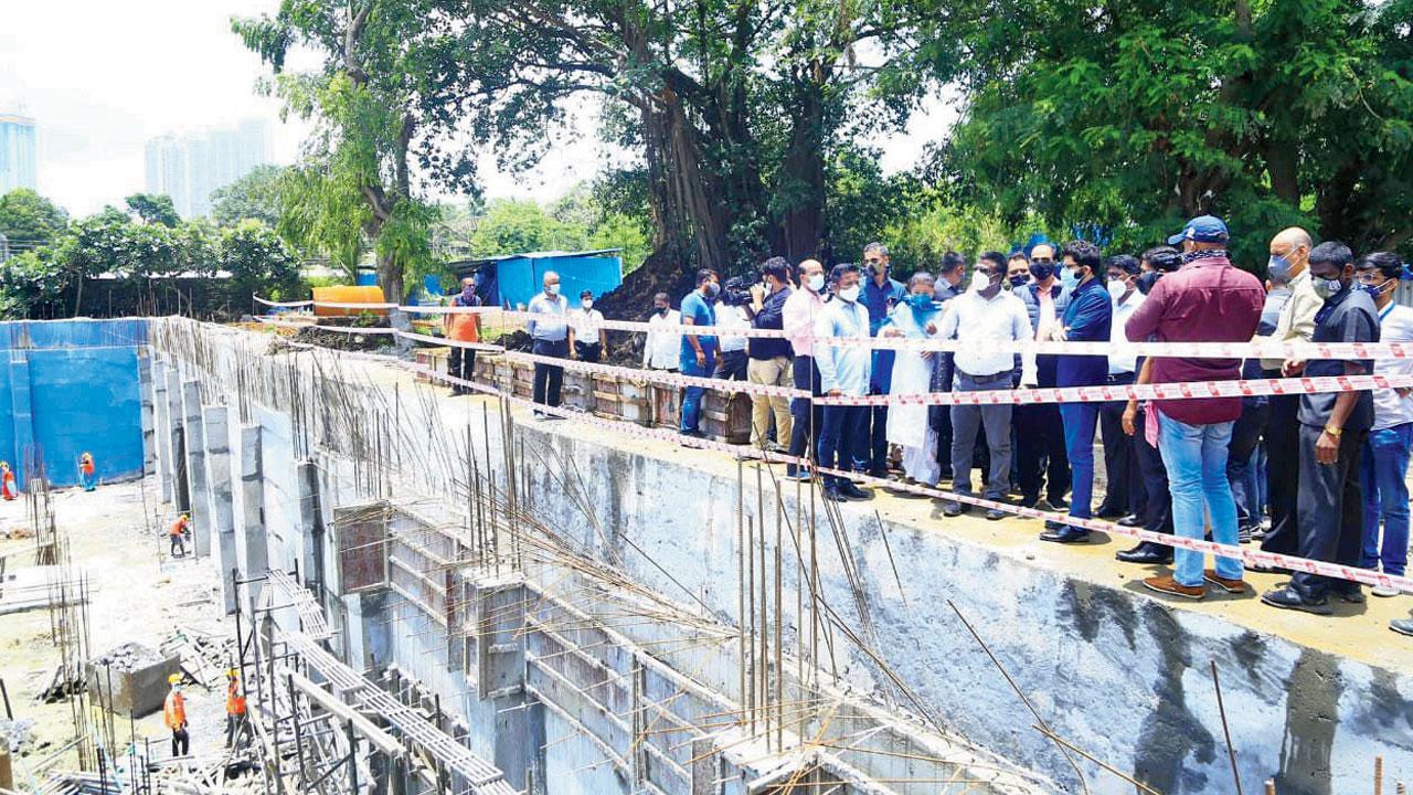Officials inspect a storage tank meant to drain water from the Hindmata junction that always floods during the monsoon