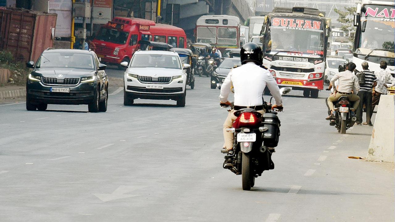 A traffic cop rides his bike, with registration MH01AG436, on the wrong side of the Western Express Highway, towards Aarey junction, at 2.51 pm on Tuesday