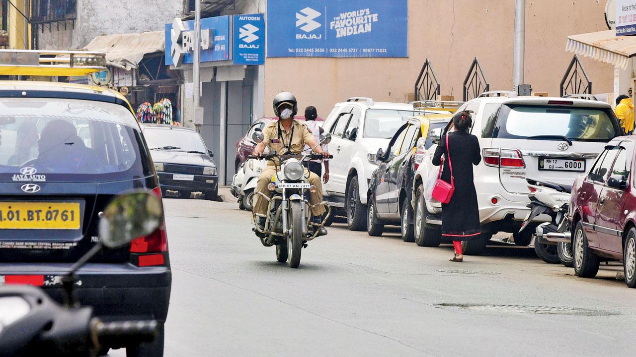 A police officer rides his patrolling bullet bearing registration number MH01AN2471 on the wrong side of the Old Cadell Road, Mahim West, at 12.17 pm on Tuesday