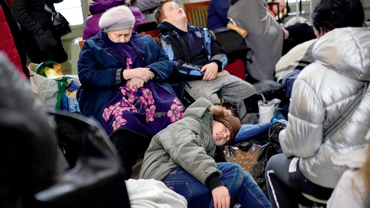 People who fled Ukraine sleep at the Przemysl train station in Poland on Wednesday