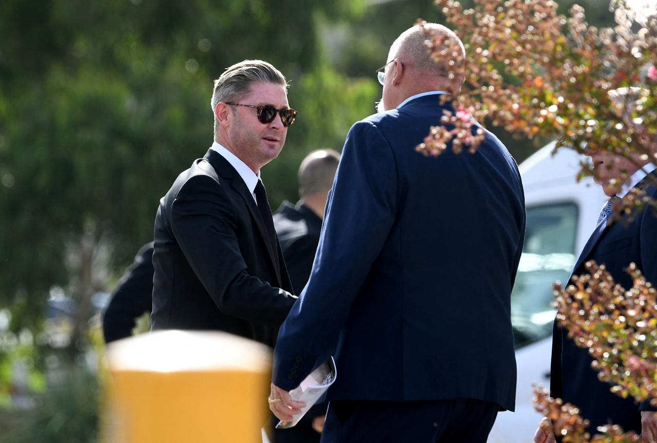 Former Australian cricketers Michael Clarke (L) and Merv Hughes (R) chat as they arrive for a private memorial service for Australian cricket superstar Shane Warne in Melbourne